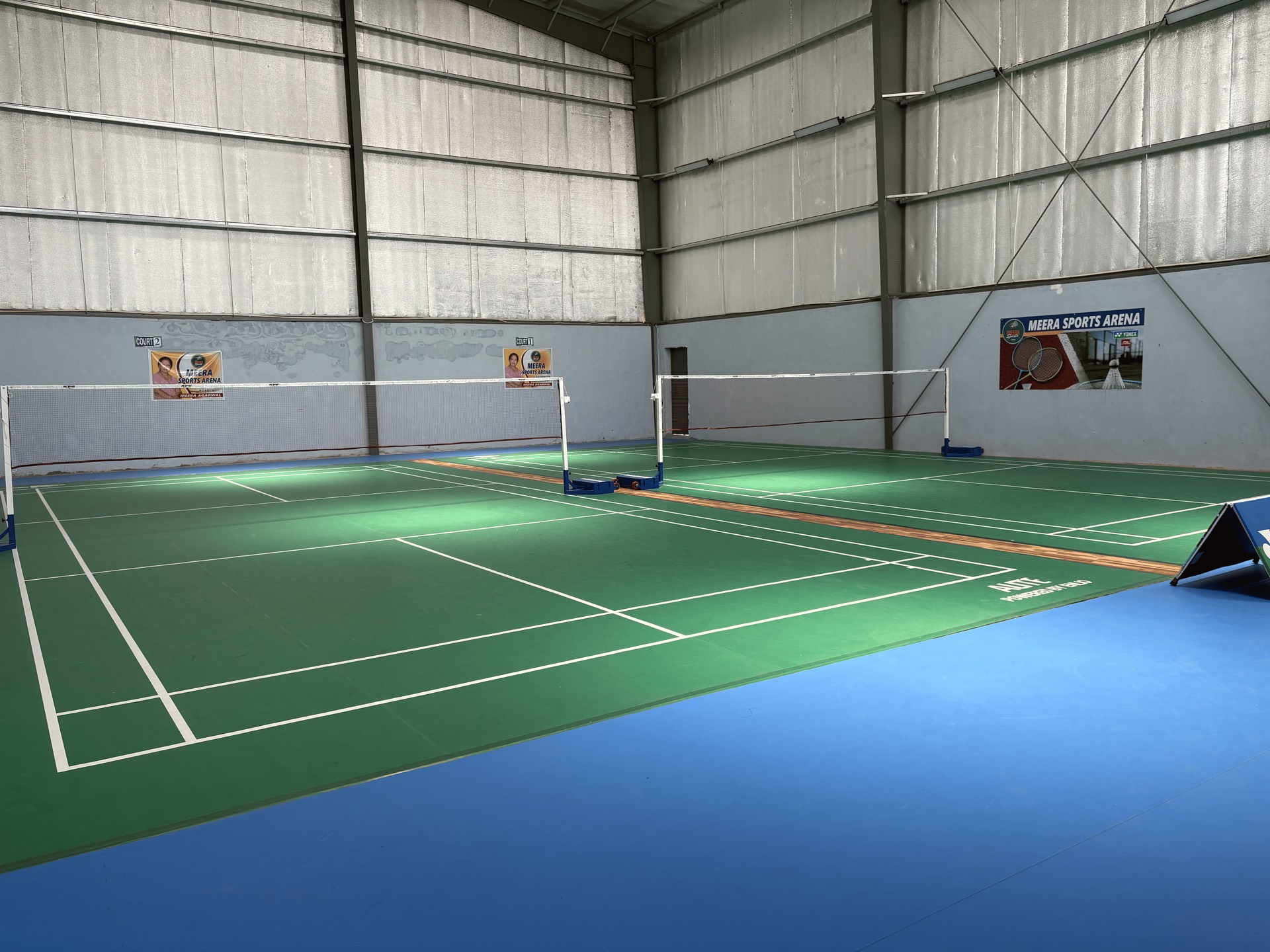 The two wooden courts at Meera Sports Arena in daylight